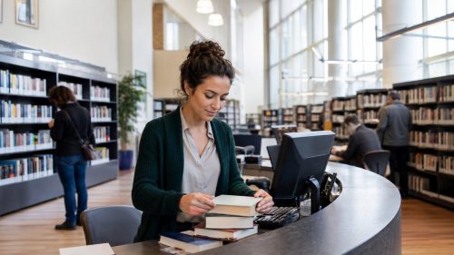 Donna al lavoro in biblioteca